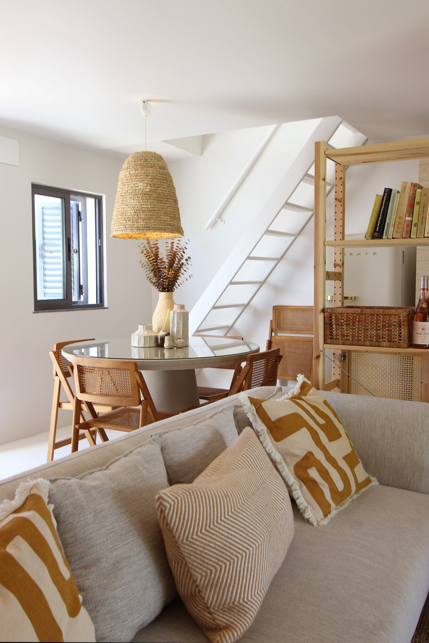 Sala de jantar clara com escada em madeira, projeto Alfarim